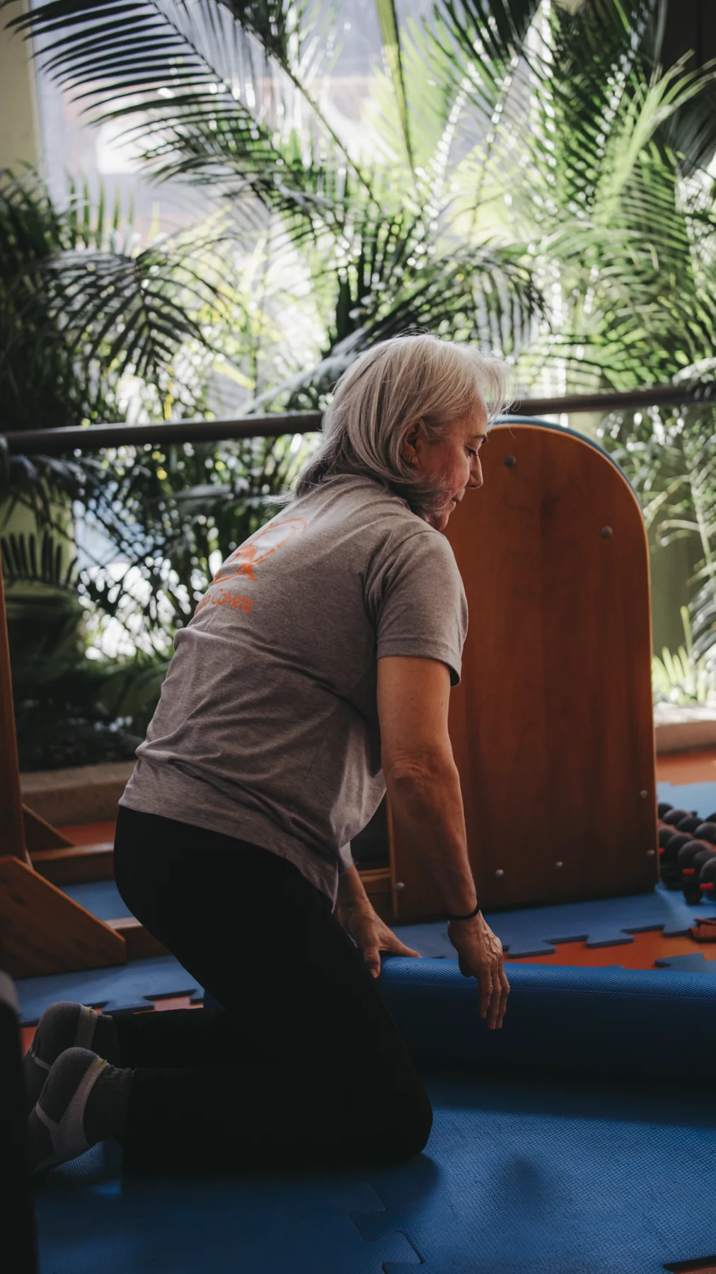 Aluna realizando um exercício no solo junto às janelas do Studio